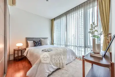 Luxurious bedroom with floor-to-ceiling windows and elegant decor in modern apartment.