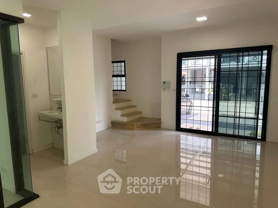 Spacious modern interior with large windows and sleek tile flooring, ideal for contemporary living.
