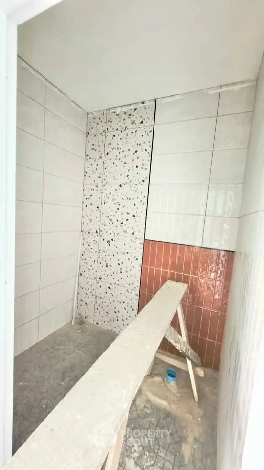 Modern bathroom under construction with stylish tile design and spacious layout.