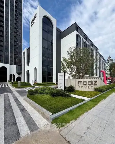 Modern high-rise building with sleek design and lush landscaping, perfect for urban living.