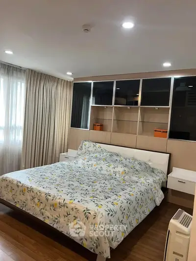 Spacious bedroom with modern decor and large windows for natural light.