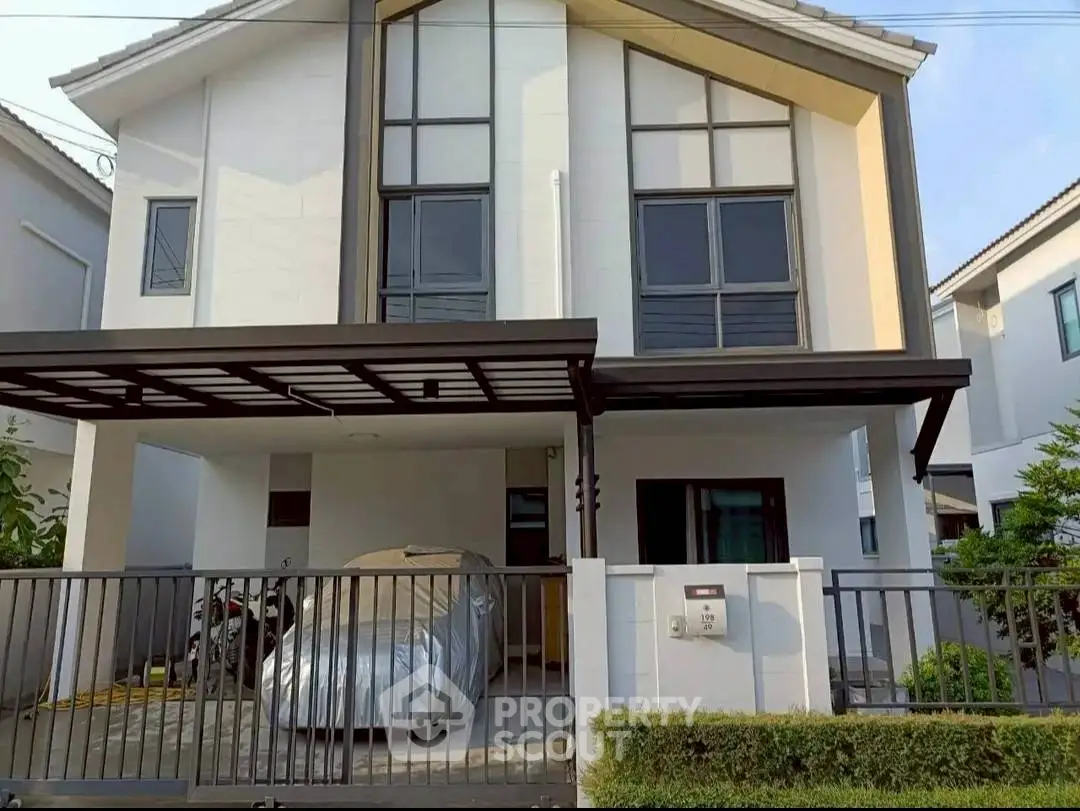 Modern two-story house with sleek design and covered parking in a serene neighborhood.