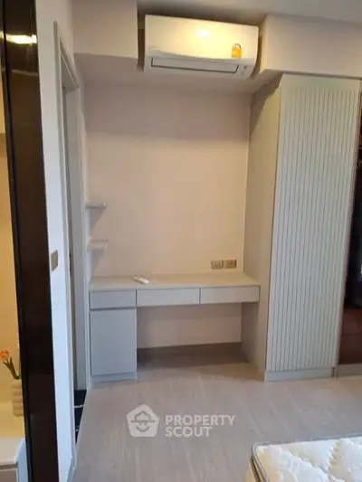 Modern bedroom with built-in wardrobe and air conditioning unit