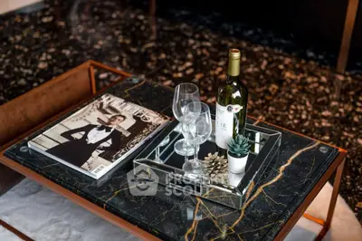 Elegant coffee table with wine, glasses, and decor in stylish living room.