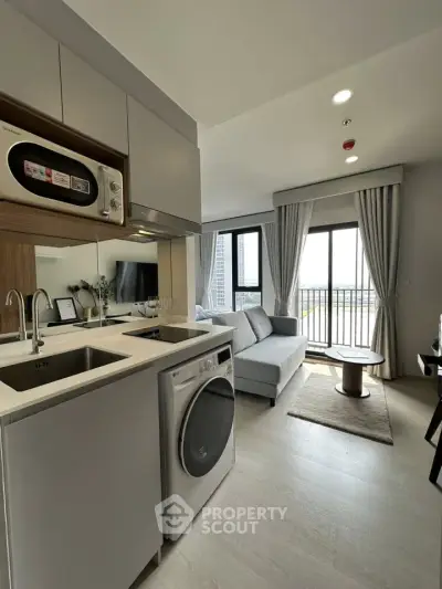 Modern living room with open kitchen and balcony view in stylish apartment