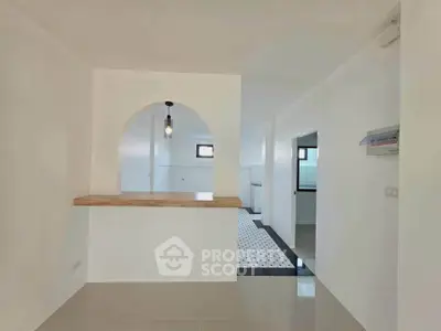 Modern open-plan kitchen with stylish archway and sleek tile flooring