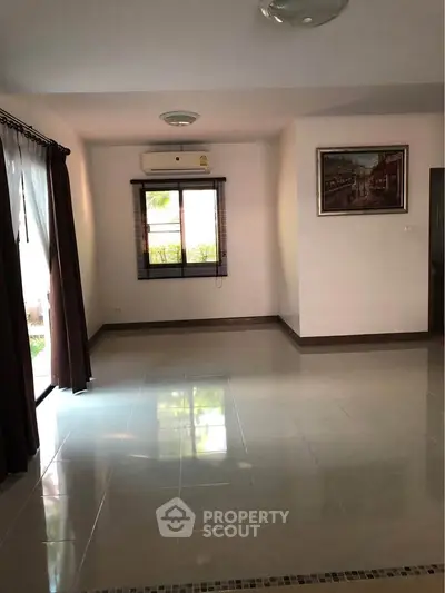 Spacious living room with large windows and air conditioning, perfect for natural light and comfort.