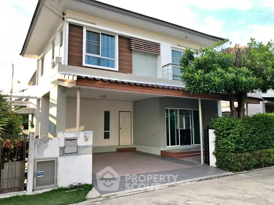 Modern two-story house with spacious driveway and lush greenery