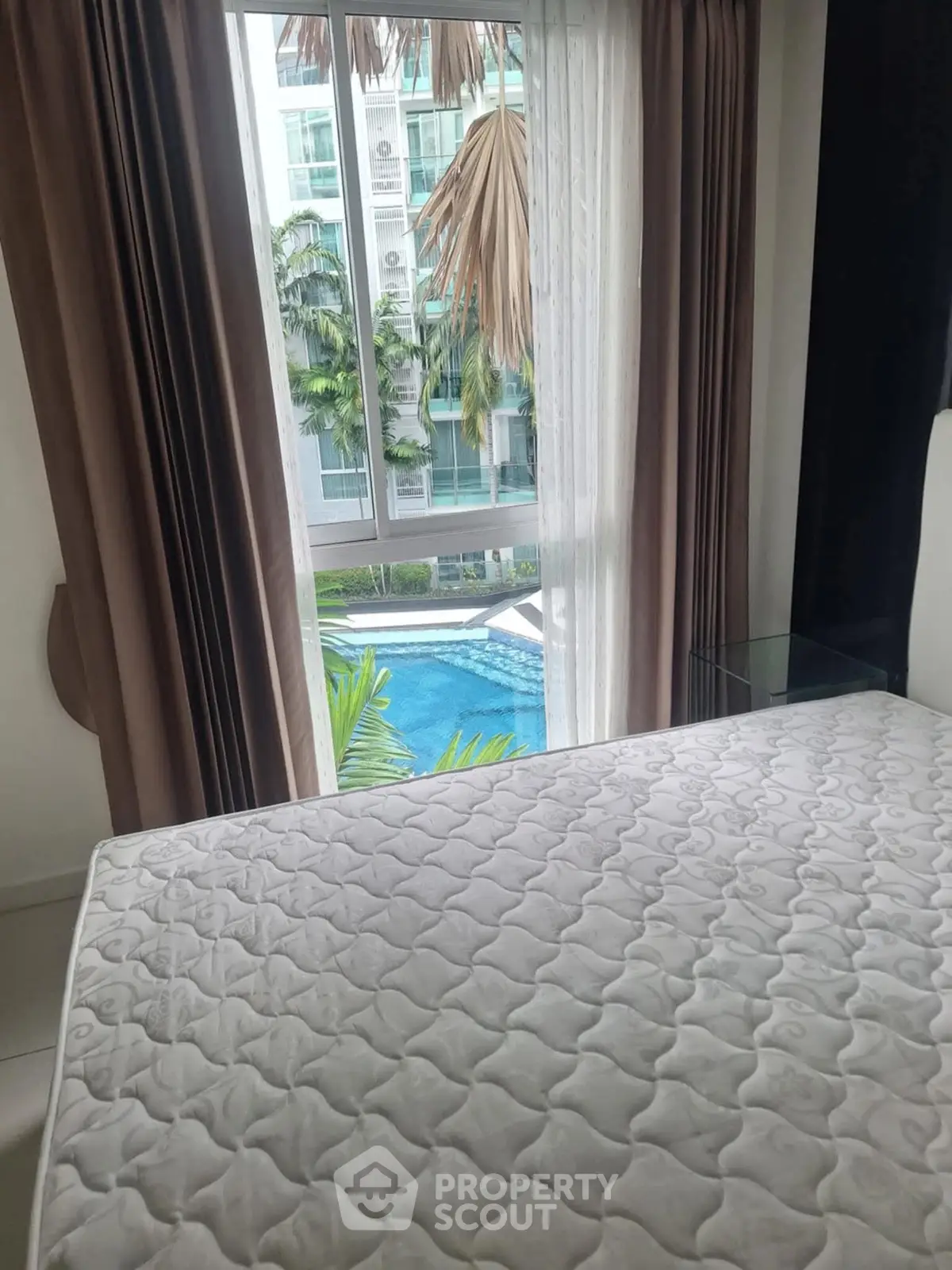 Bedroom with pool view, featuring a large window and modern design.