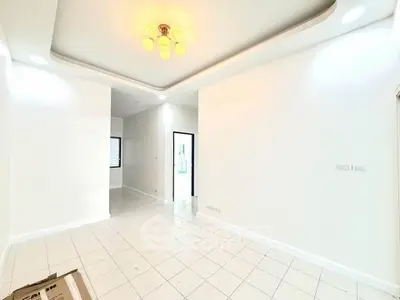 Spacious and bright living room with modern ceiling light and tiled flooring.