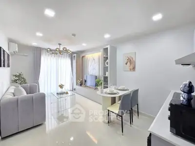 Modern living room with elegant decor and open dining area, featuring stylish furniture and bright lighting.