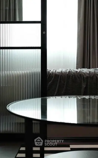 Modern interior with glass table and stylish curtains in a contemporary living space.