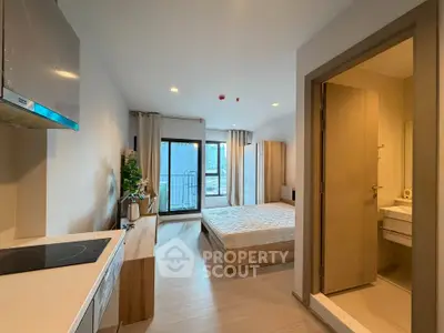 Modern studio apartment with open layout, featuring a cozy bedroom, compact kitchen, and balcony access.
