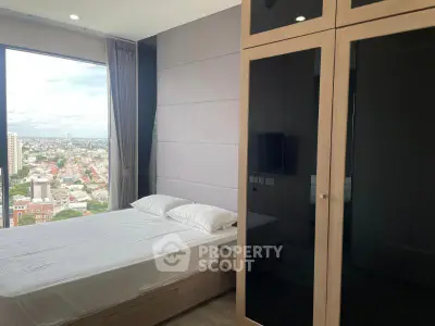 Modern bedroom with large window offering stunning city view, featuring sleek wardrobe and minimalist decor.