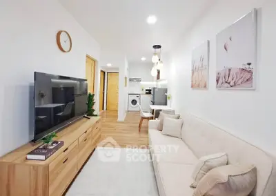 Modern living room with cozy sofa, wall art, and wooden flooring