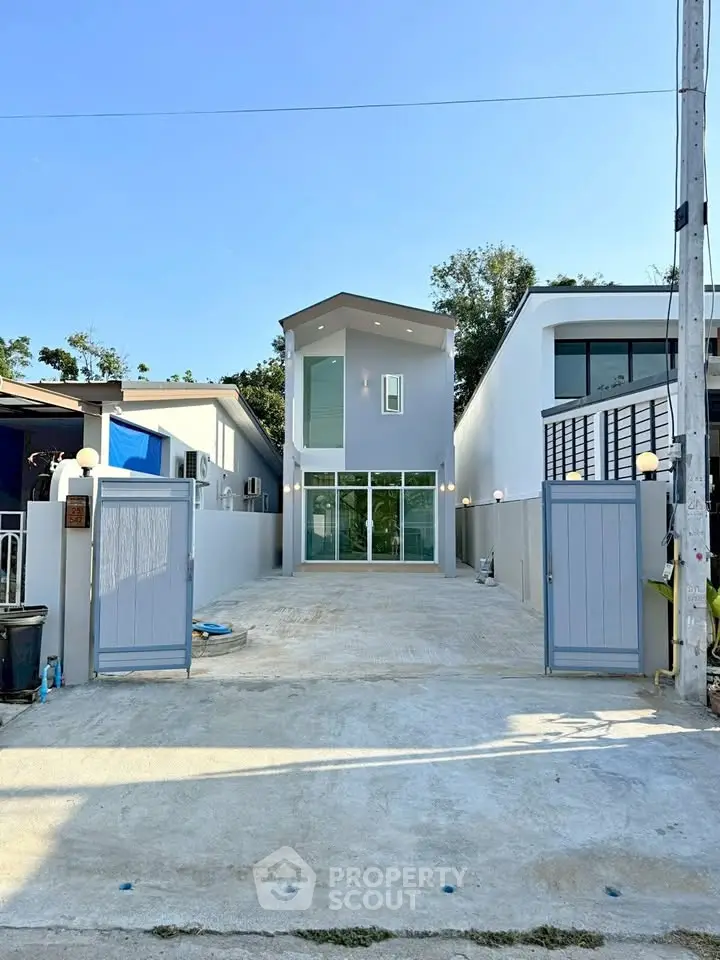 Modern two-story house with sleek design and spacious driveway, perfect for contemporary living.