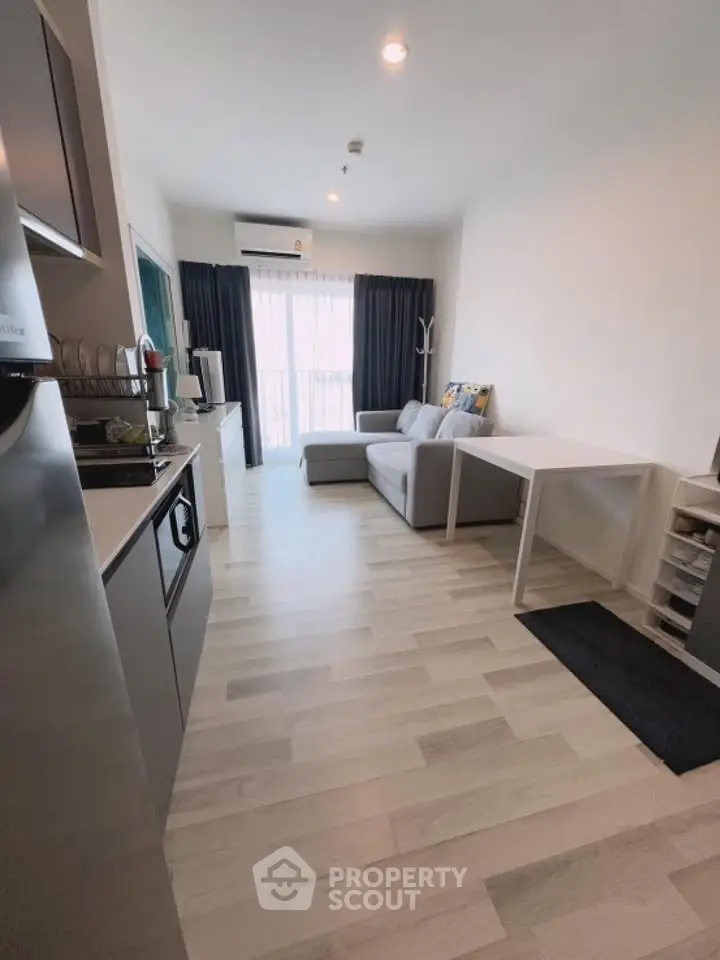 Modern living room with sleek kitchen and cozy sofa, perfect for urban living.