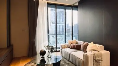 Modern living room with city view, featuring stylish sofa and glass coffee table.