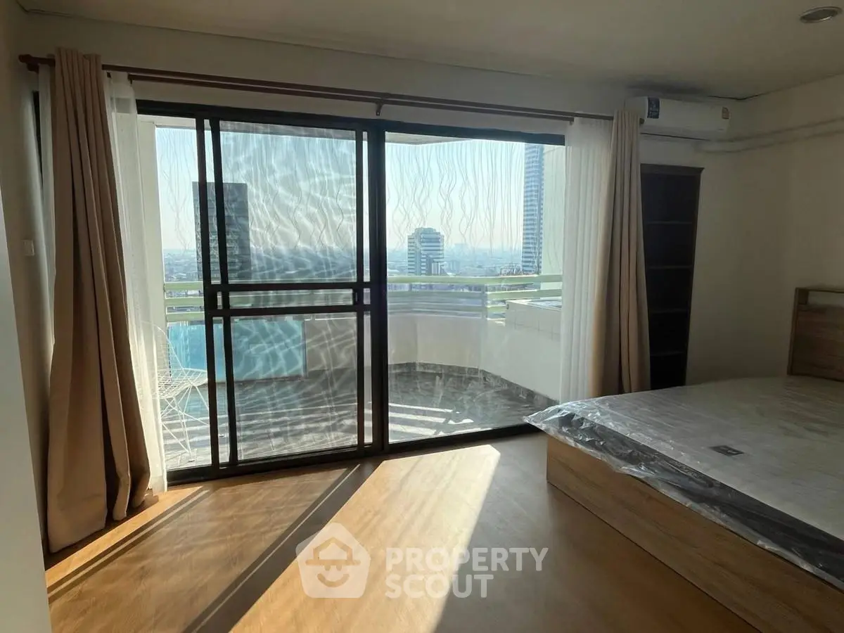 Spacious bedroom with balcony offering stunning city views in modern apartment
