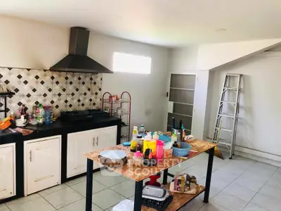 Spacious kitchen with modern range hood and ample counter space.