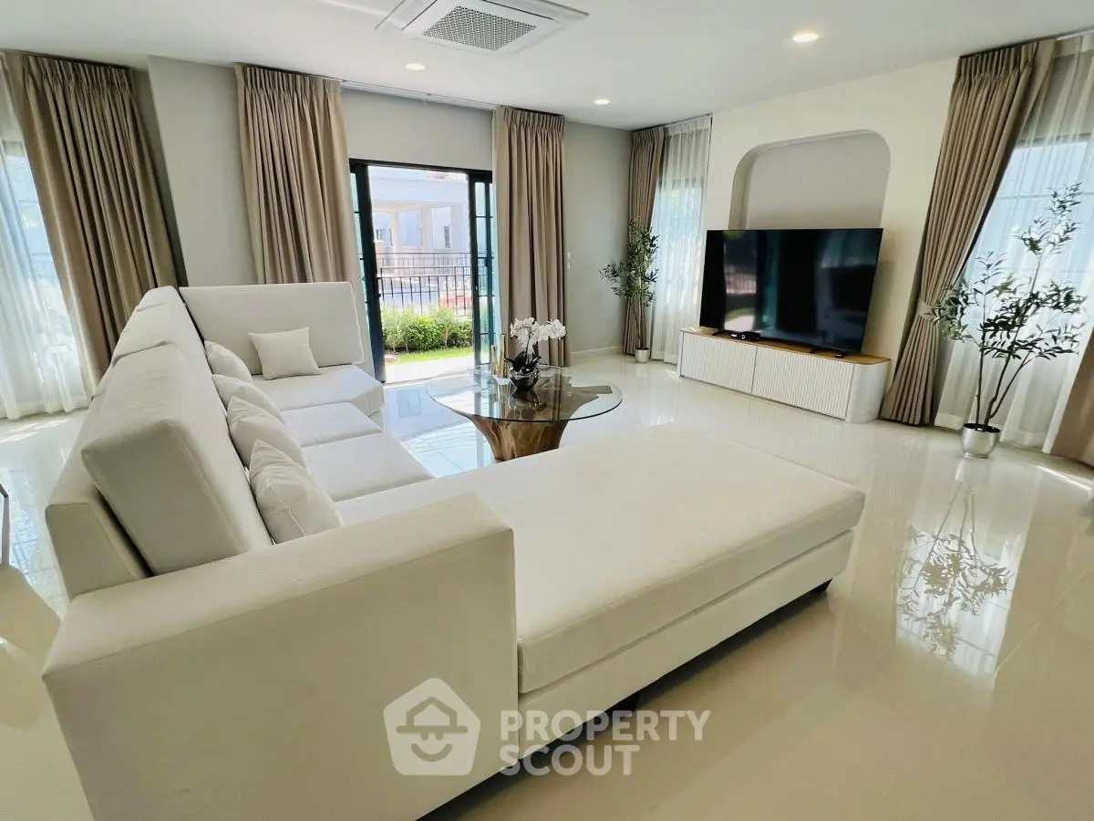 Spacious modern living room with elegant white sofa and large TV