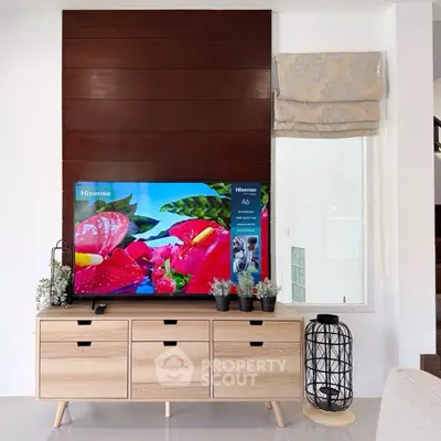 Modern living room with stylish wooden TV console and decorative plants