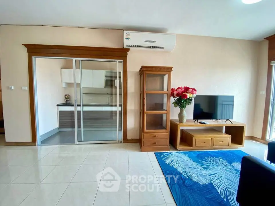 Spacious living room with modern decor and sliding glass doors to kitchen