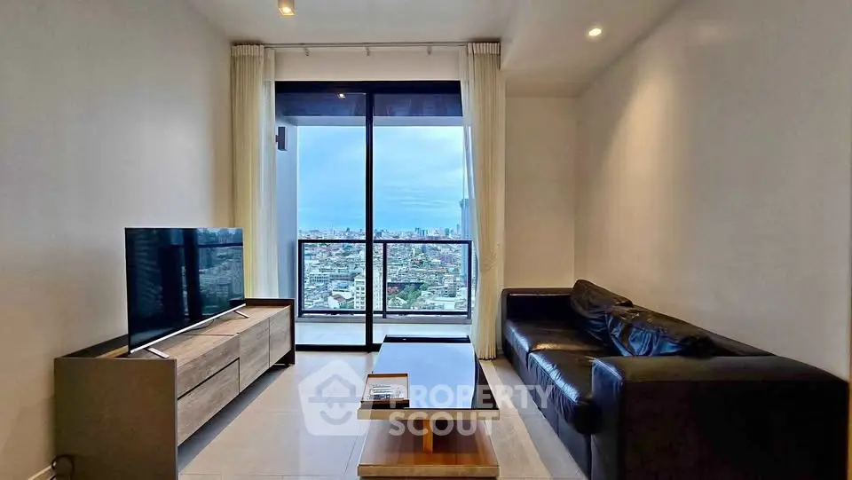 Modern living room with city view, sleek furniture, and large window for natural light.
