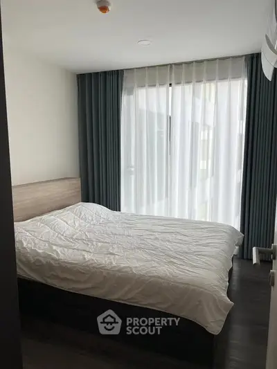 Cozy bedroom with modern decor and large window for natural light