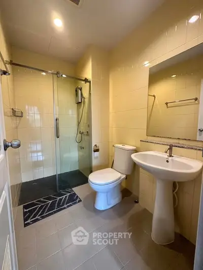 Modern bathroom with glass shower and sleek fixtures in a contemporary home.