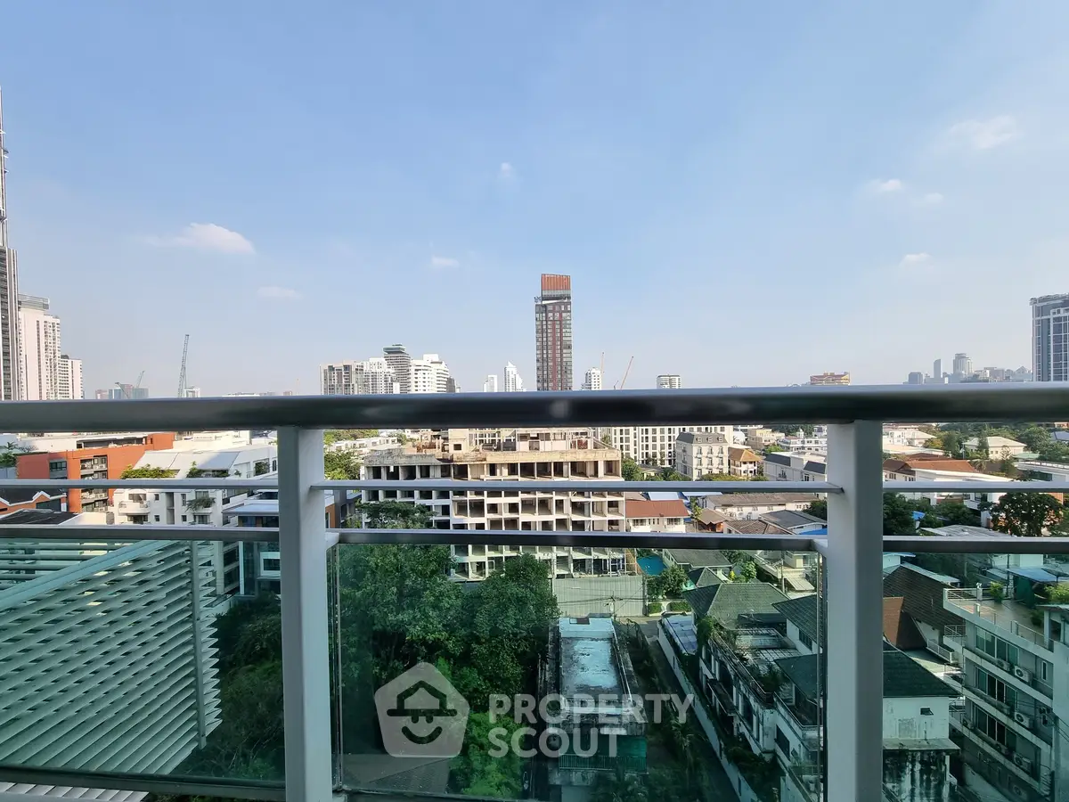 Stunning cityscape view from a high-rise balcony with clear blue skies.