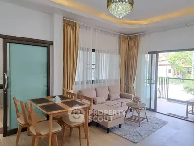 Elegant living room with modern furniture and large windows opening to a balcony, perfect for relaxation.