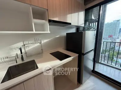 Modern kitchen with sleek appliances and city view from balcony