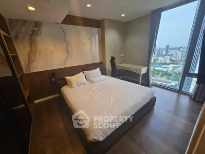 Modern bedroom with city view, featuring a comfortable bed and stylish decor.