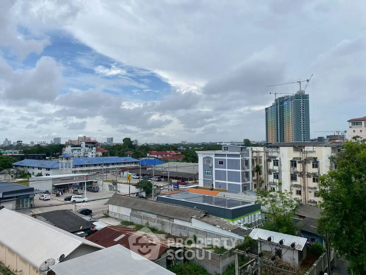 Urban skyline view with residential and commercial buildings under a cloudy sky.