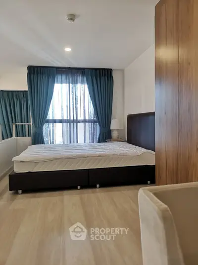 Spacious bedroom with large window and elegant curtains in modern apartment