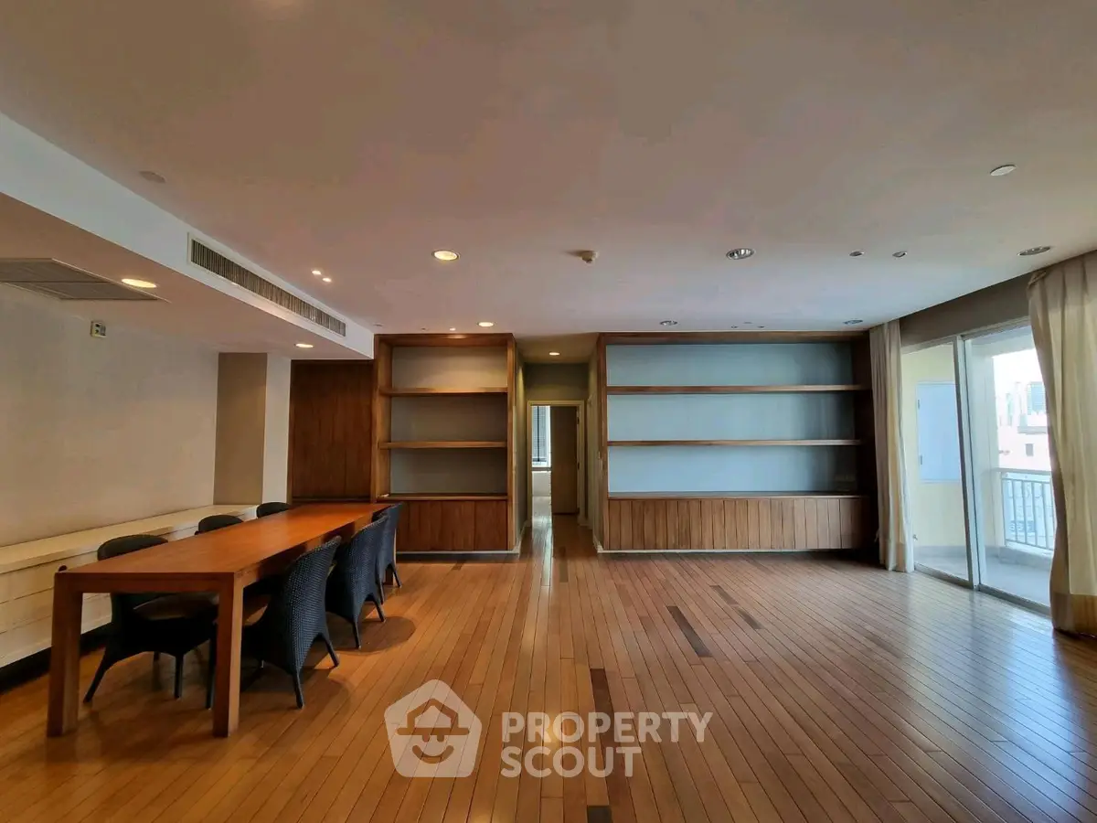 Spacious living room with wooden flooring and built-in shelves, perfect for modern living.
