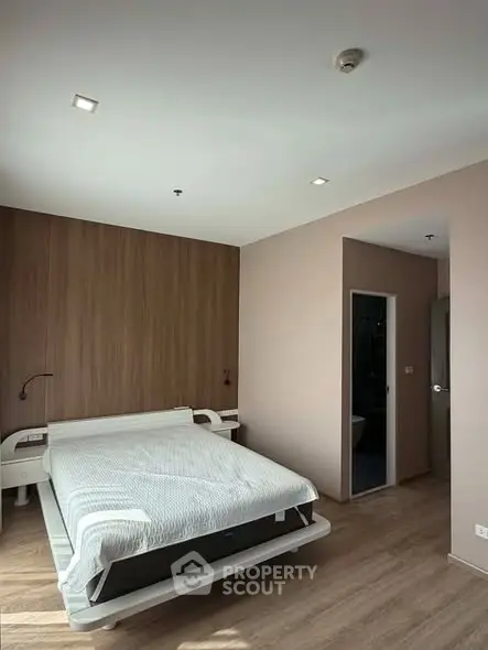 Modern bedroom with sleek design and wooden accents, featuring a cozy bed and minimalist decor.