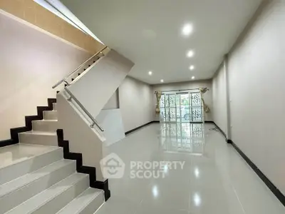 Spacious modern living room with sleek staircase and large windows