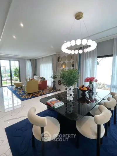 Luxurious open-plan living and dining area with modern decor and elegant lighting.