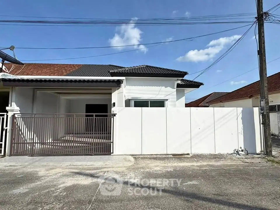 Charming single-story home with modern facade and gated driveway in a serene neighborhood.