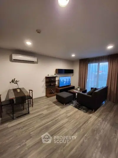 Modern living room with stylish furniture and large window, featuring a cozy ambiance and elegant decor.