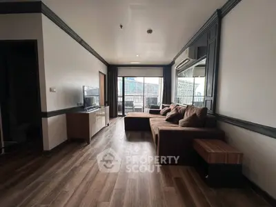 Spacious living room with modern decor and large windows offering city views