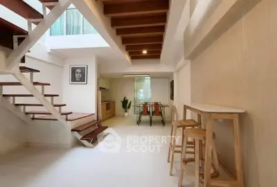 Modern open-plan living space with stylish staircase and dining area