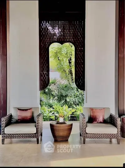 Luxurious seating area with elegant chairs and lush garden view, perfect for relaxation.
