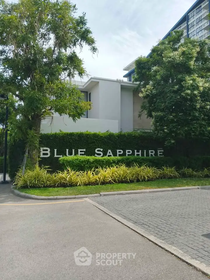 Elegant exterior view of Blue Sapphire building surrounded by lush greenery and modern architecture.