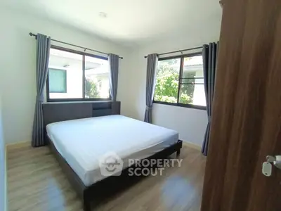 Bright and airy bedroom with large windows and modern furnishings