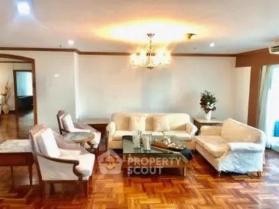 Spacious living room with elegant chandelier and cozy seating area, perfect for relaxation and entertaining.