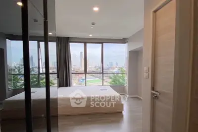 Spacious bedroom with large windows offering stunning city views