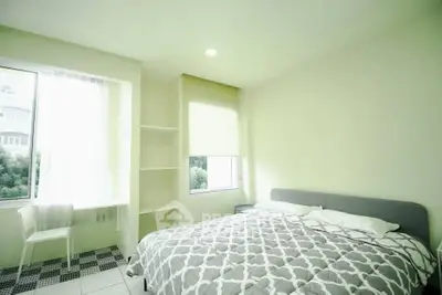 Bright and airy bedroom with modern decor and large window view.